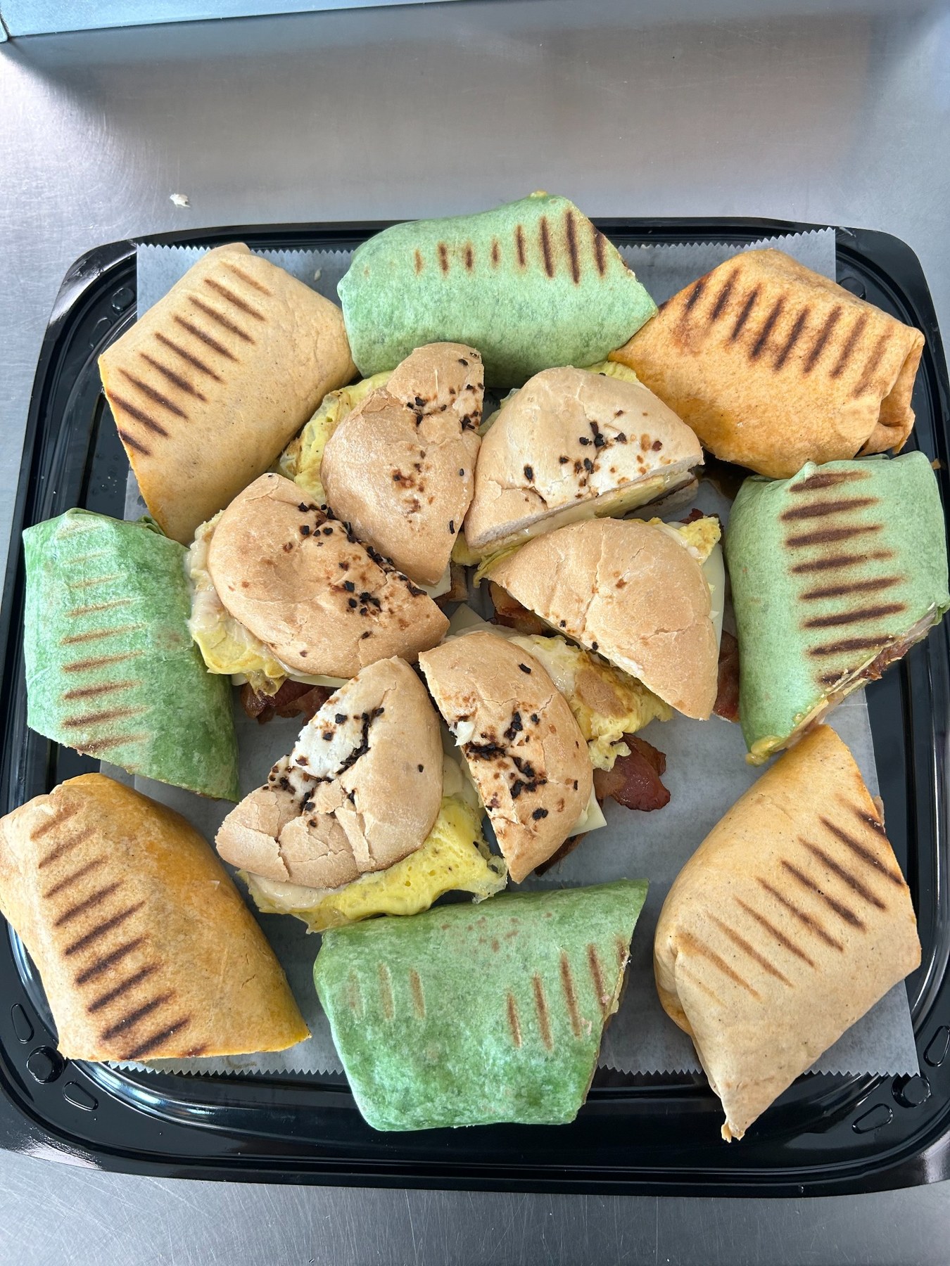 Dockside breakfast catering platter with breakfast burritos, sandwiches, and fresh fruit